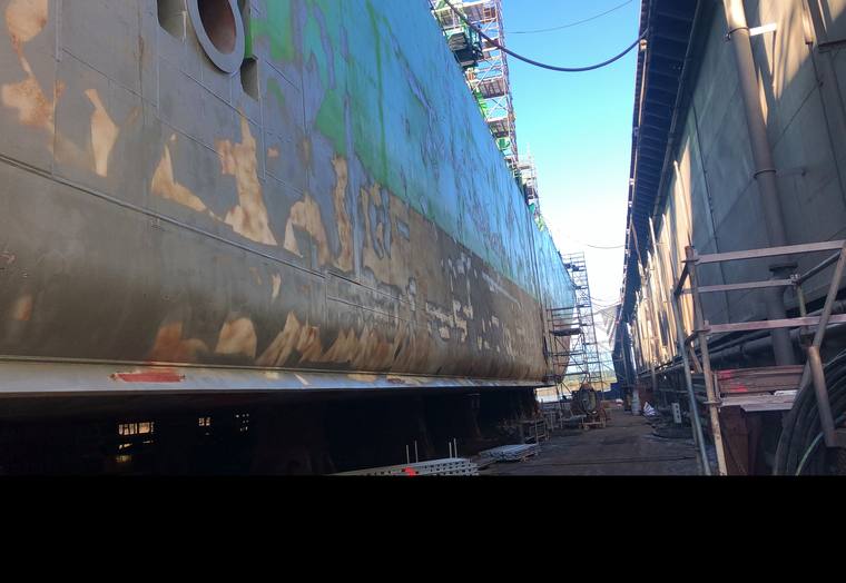 Straalwerk aan een scheepsromp in droogdok